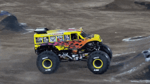a monster truck that looks like a school bus is driving on a dirt road