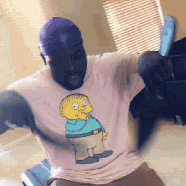 a man wearing a purple hat and a pink shirt with ralph simpson on it