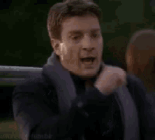 a man in a suit and tie is making a funny face with his hand on his chin .