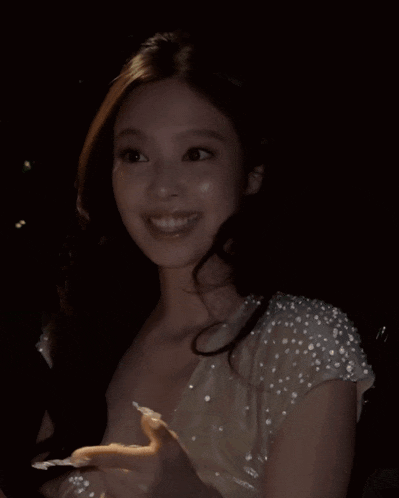 a woman in a white dress with pearls on her sleeves