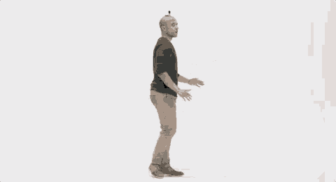a bald man is standing in front of a white wall with a camera on his head .