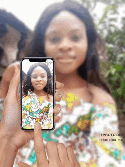 a person is taking a picture of a girl on a cellphone