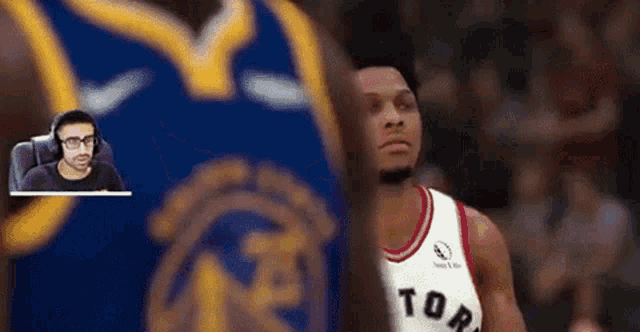 a man is playing a video game with a basketball player in a toronto raptors jersey .