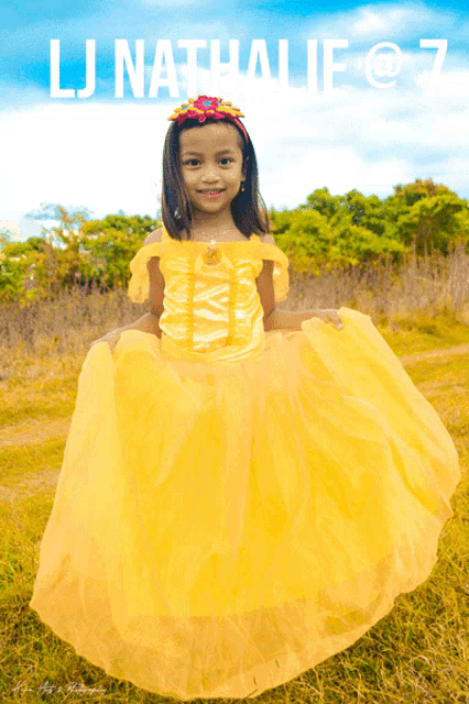 a little girl wearing a yellow dress with the name lj nathalie on the bottom