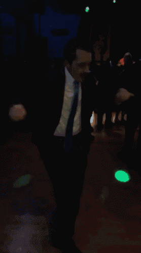 a man in a suit and tie is dancing on the dance floor