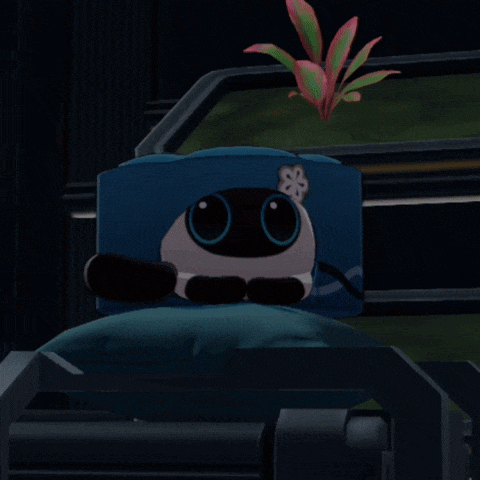 a stuffed animal with a flower on its head is sitting on a bed