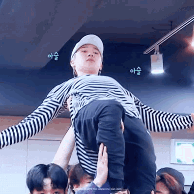 a man in a striped shirt is being lifted in the air