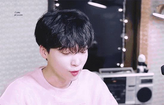 a young man wearing a pink shirt with the word come on it