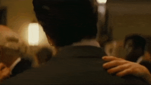 a man in a suit is standing in a dark hallway with a quote on the bottom