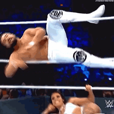 a man and a woman are wrestling in a wrestling ring . the woman is holding the man 's leg .