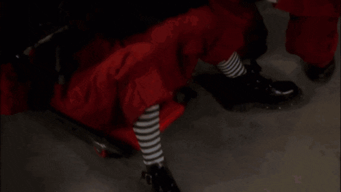 a woman in a red shirt with the letter s on it is laying on a bed
