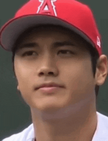 a close up of a baseball player wearing a red hat and a white shirt .