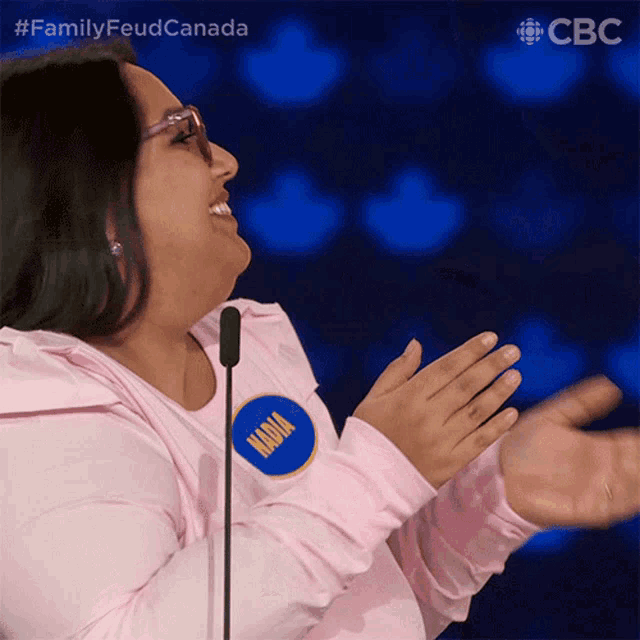 a woman wearing a pink shirt with a name tag that says nadya