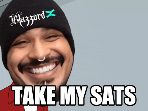 a man wearing a beanie with the word blazord on it smiles and says take my sats