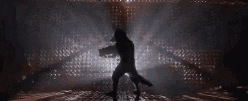 a man is holding a gun in a dark room .