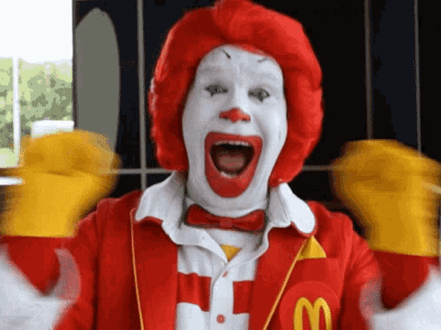 a mcdonald 's clown is wearing a red and white outfit