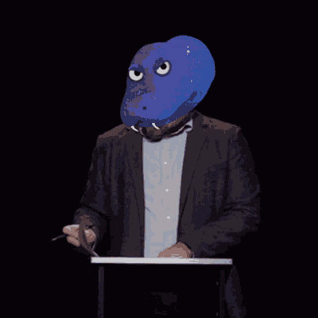 a man in a suit has a snake mask on his head and says " no " in white letters