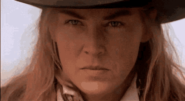 a close up of a woman 's face wearing a cowboy hat