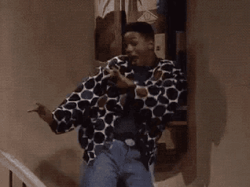 a man in a polka dot shirt is dancing with the words boom demais written on the bottom .