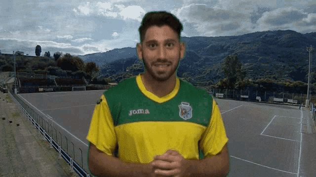 a man is wearing a yellow and green joma jersey