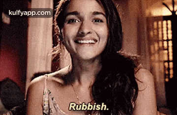 a woman is smiling with the words rubbish written on her face .