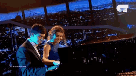 a man and a woman are playing piano in front of a city skyline