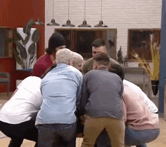 a group of people are standing in a circle in a living room .