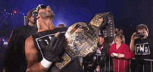 a wrestler is holding a world heavyweight wrestling championship belt .