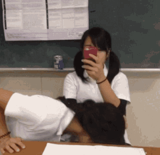 a girl is taking a picture of a boy with her cell phone