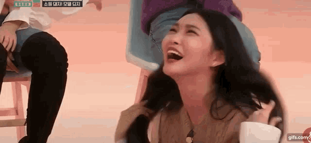 a woman is sitting on a chair with her mouth open and laughing .