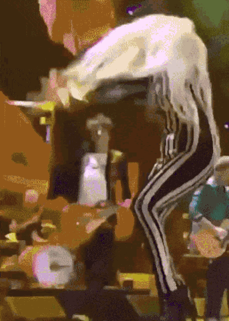 a pixelated image of a person dancing with a clock in the background