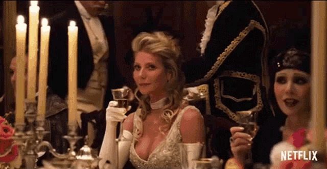 a woman sitting at a table holding a glass of wine with netflix written on the bottom right