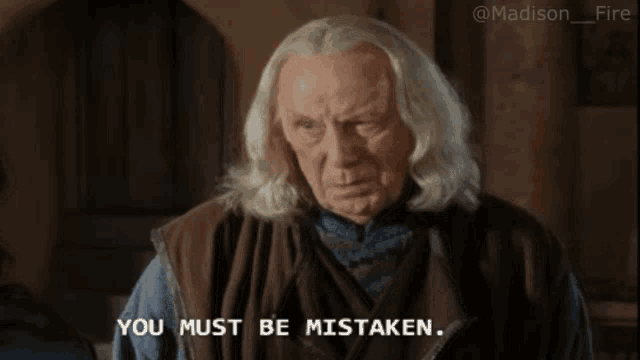 a man with gray hair and a brown vest says you must be mistaken