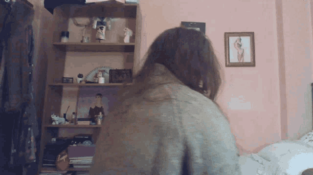 a woman is sitting in front of a bookshelf with a picture of a woman on it
