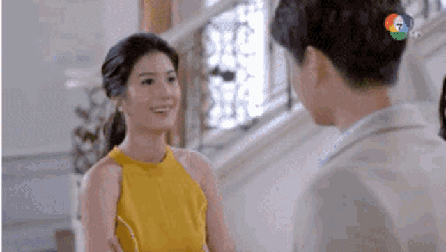 a man and a woman are talking to each other in a room .