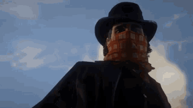 a man wearing a hat and a bandana covering his face