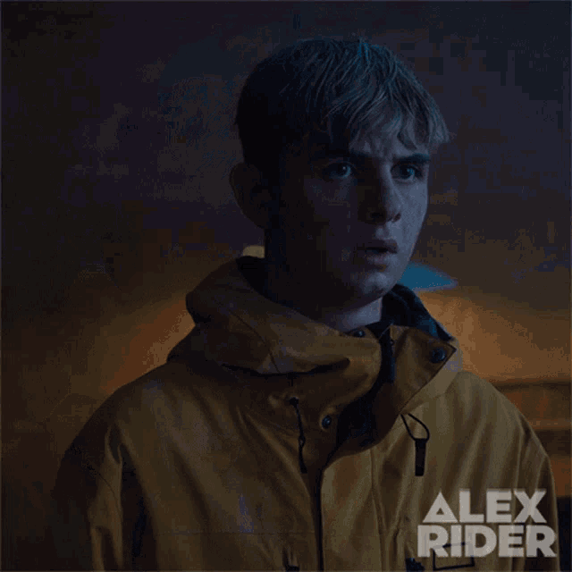 a man in a yellow jacket with alex rider written on the bottom right
