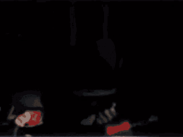 a man wearing headphones is making a funny face while holding something in his hand in a dark room .