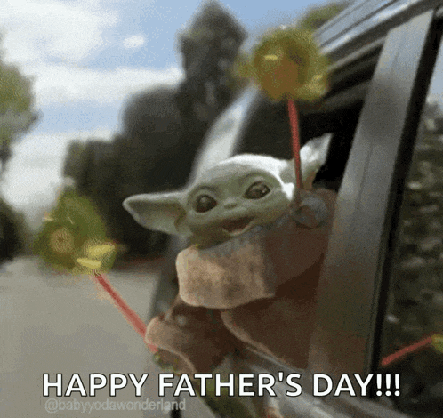 a baby yoda doll is sticking its head out of a car window .