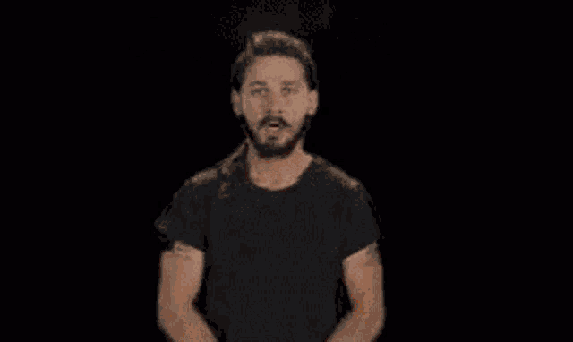 a man in a black shirt stands in front of a fire with the word troverse written on it