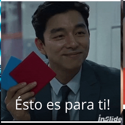 a man in a suit and tie is smiling and holding a piece of paper that says " esto es para ti " on it