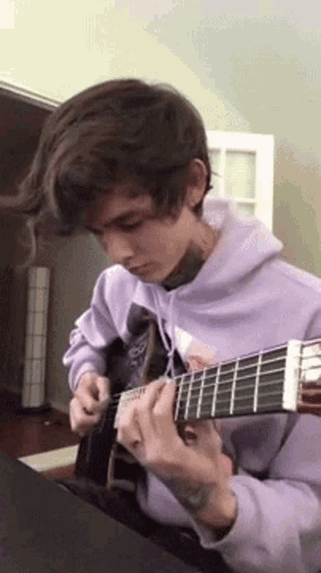 a young man is playing a guitar in a living room .