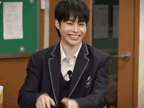 a young man in a school uniform is smiling