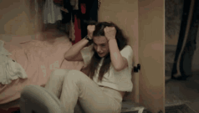 a woman is sitting on the floor in front of a wardrobe .