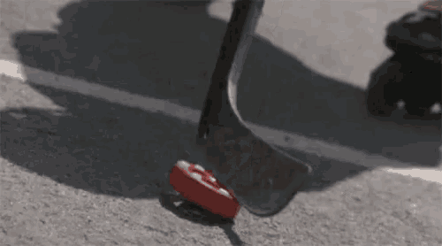 a person is holding a hockey stick on the ground .