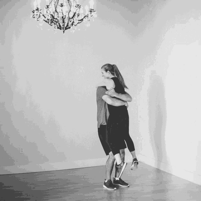 a man is carrying a woman in his arms in a room