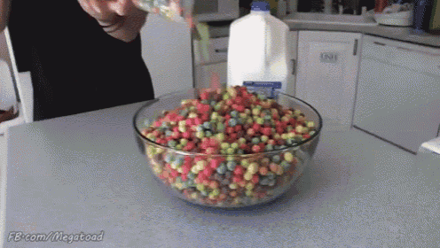 a person pouring milk into a bowl of fruity loops