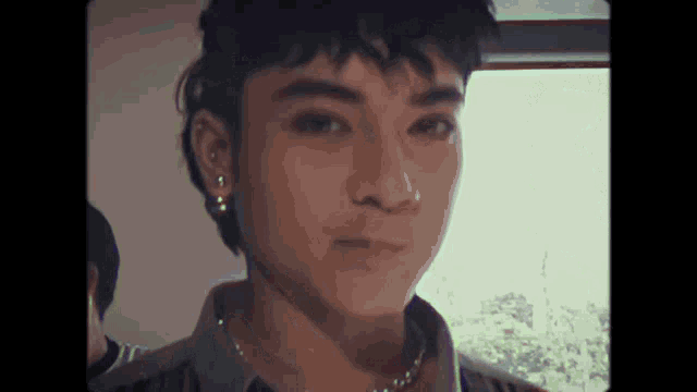 a close up of a young man 's face with a nose ring .