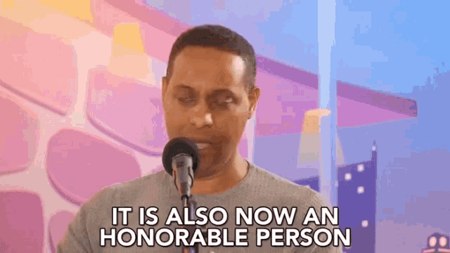 a man singing into a microphone with the words it is also now an honorable person behind him