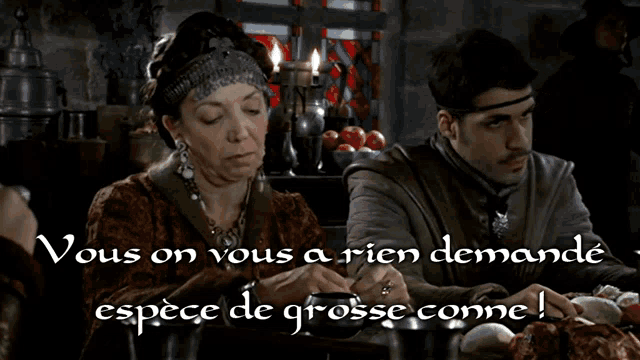 a man and a woman sit at a table with a caption that says vous on vous a rien demandé